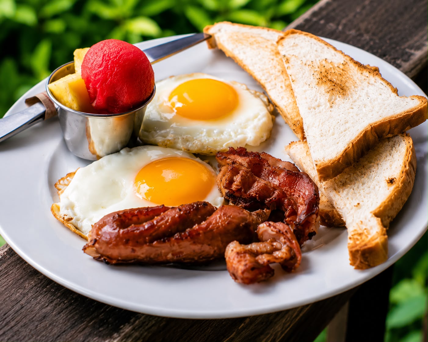 Desayuno con huevos, tocino, salchicha y pan tostado