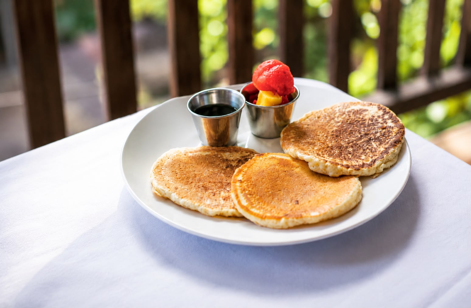 Panqueques con miel y fruta fresca en la terraza