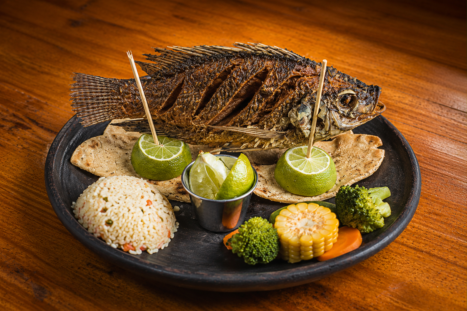 Pescado frito entero con arroz, verduras y tortillas