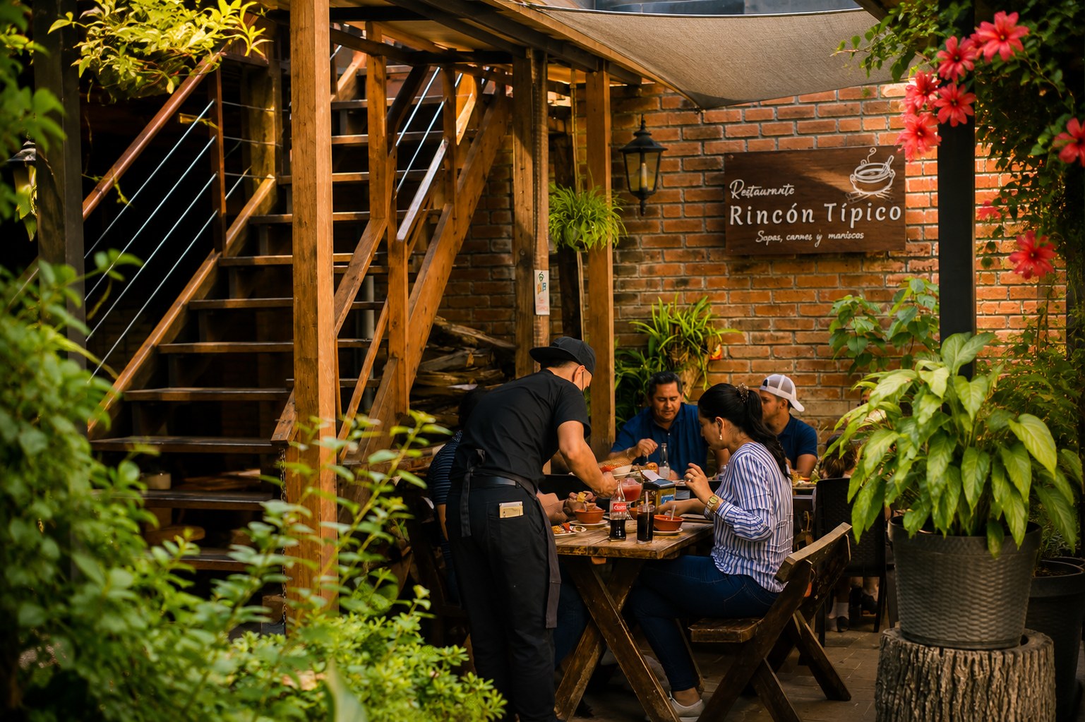 Familias y amigos compartiendo la mesa en el jardín de Restaurante Rincón Típico